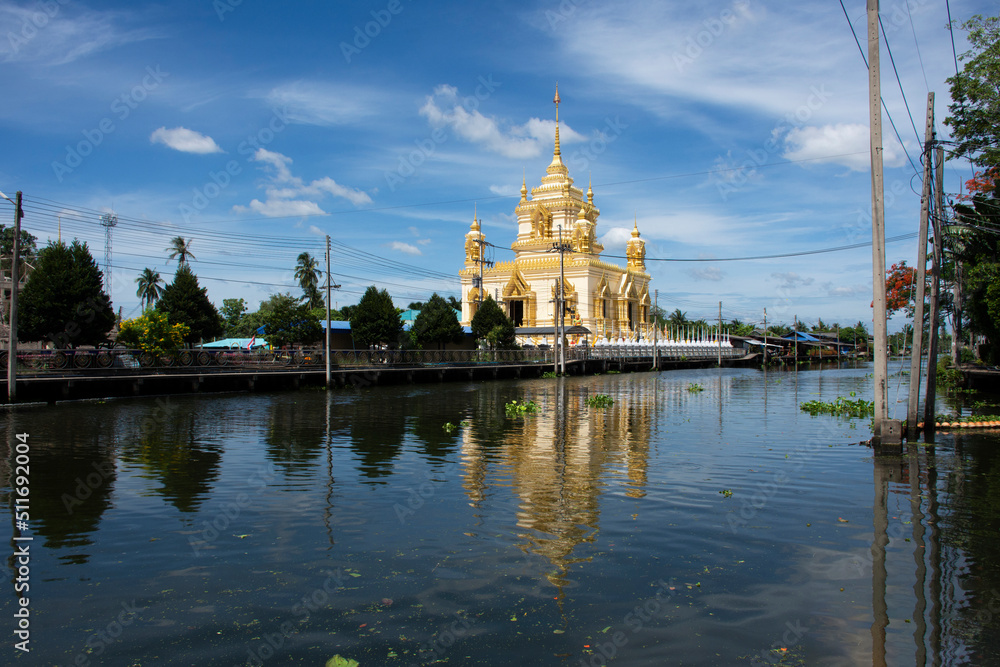 View landscape of Khlong Damnoen Saduak canal and water flowing with cityscape countryside rural village at Stupa Chedi of Wat Thammachariya Phirom temple at Ban Phaeo city in Samut Sakhon, Thailand