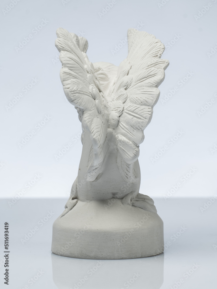 plaster white statuette in the form of an angel on a white background plaster white statuette in the form of an angel on a white background