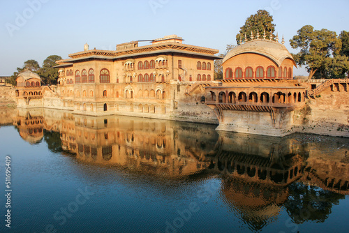 The exterior facade of the ancient royal palace rising above the waters of a lake in the town of Deeg. photo