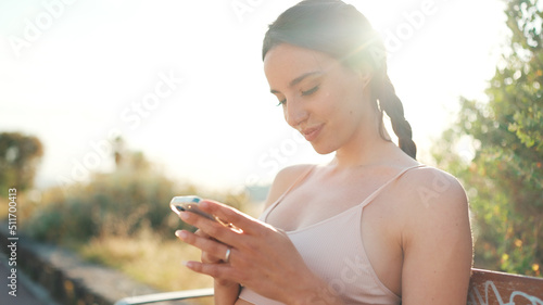 Obraz na plátně Young athletic woman with braided pigtail wearing beige sports top is sitting on
