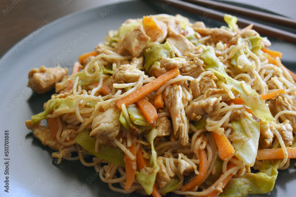 Chicken chow mein on a black plate. Traditional Chinese food. Chicken chow mein on a black plate. Traditional Chinese food.