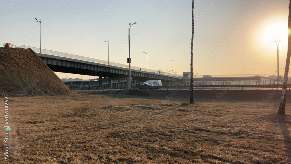 Beautiful sunset over the ring road. View of the bridge on which a person is walking. Cars move on the road. Beautiful sunset over the ring road. View of the bridge on which a person is walking. Cars move on the road.