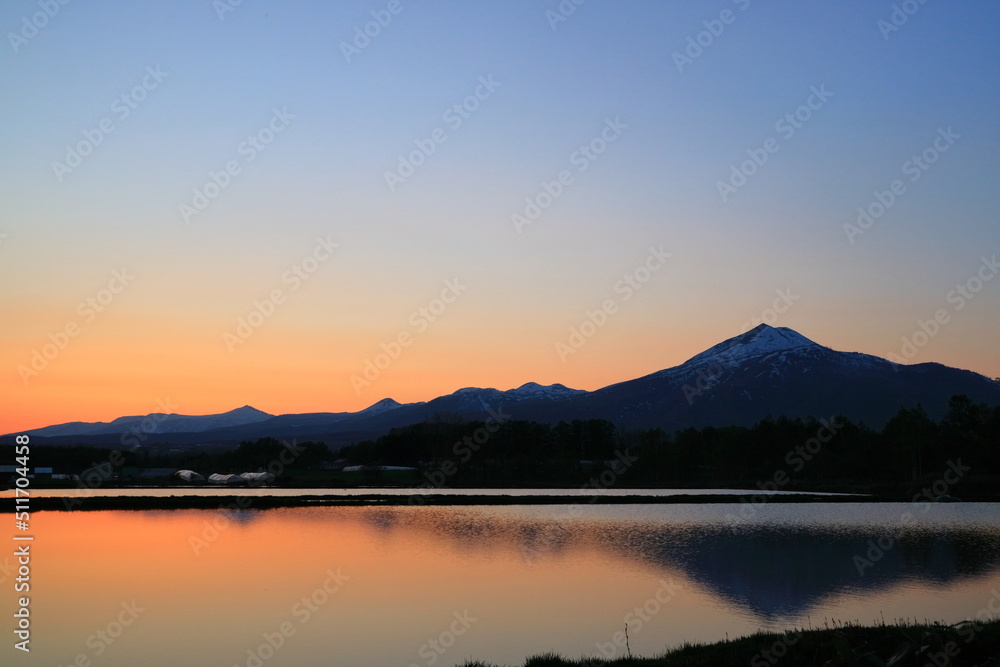 北海道　夕暮れ時、水面に映るニセコ山系
