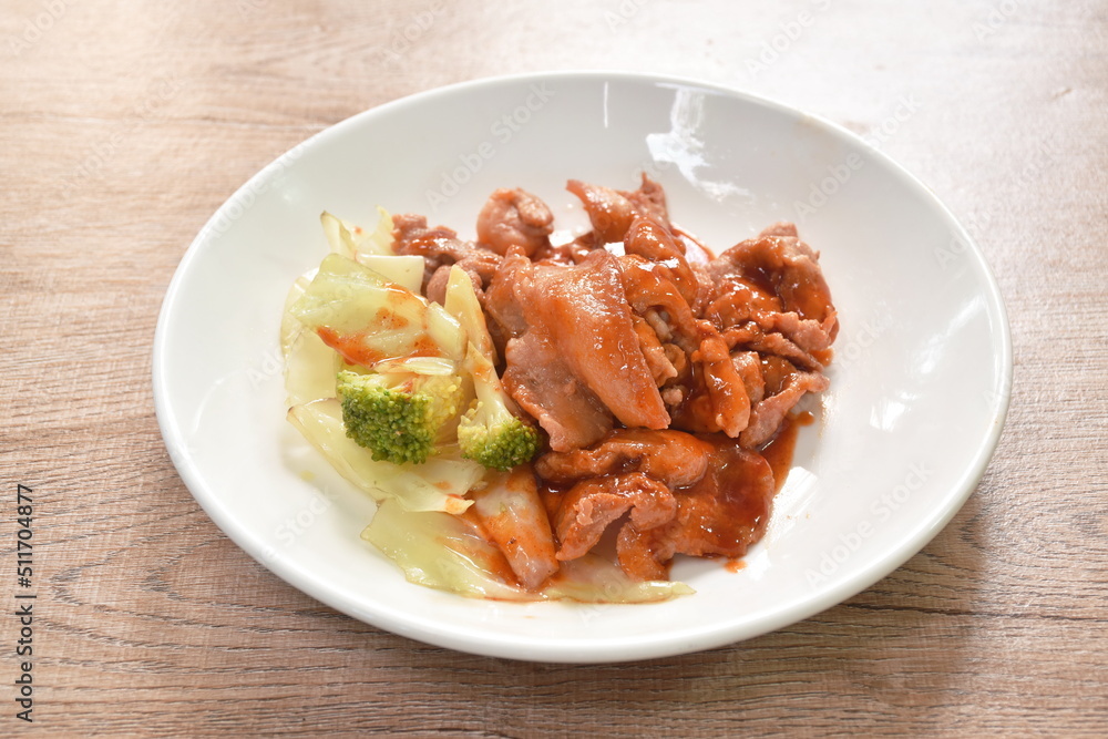 Korean fried slice pork with cabbage dressing spicy barbecue sauce on plate Korean fried slice pork with cabbage dressing spicy barbecue sauce on plate