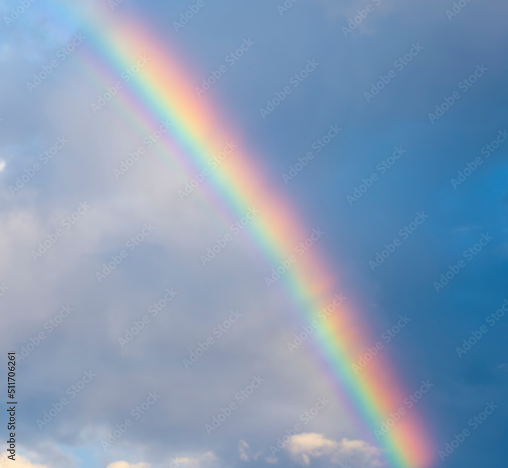 amazing bright rainbow in beautiful evening cloudy sky after rain and thunder, weather concept