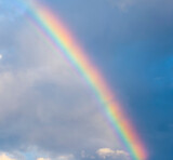 amazing bright rainbow in beautiful evening cloudy sky after rain and thunder, weather concept