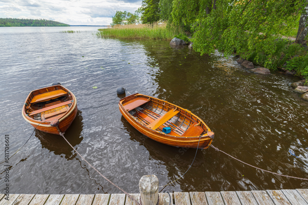 Beautiful view of lake with two boats parked in shore on water background. Sweden.