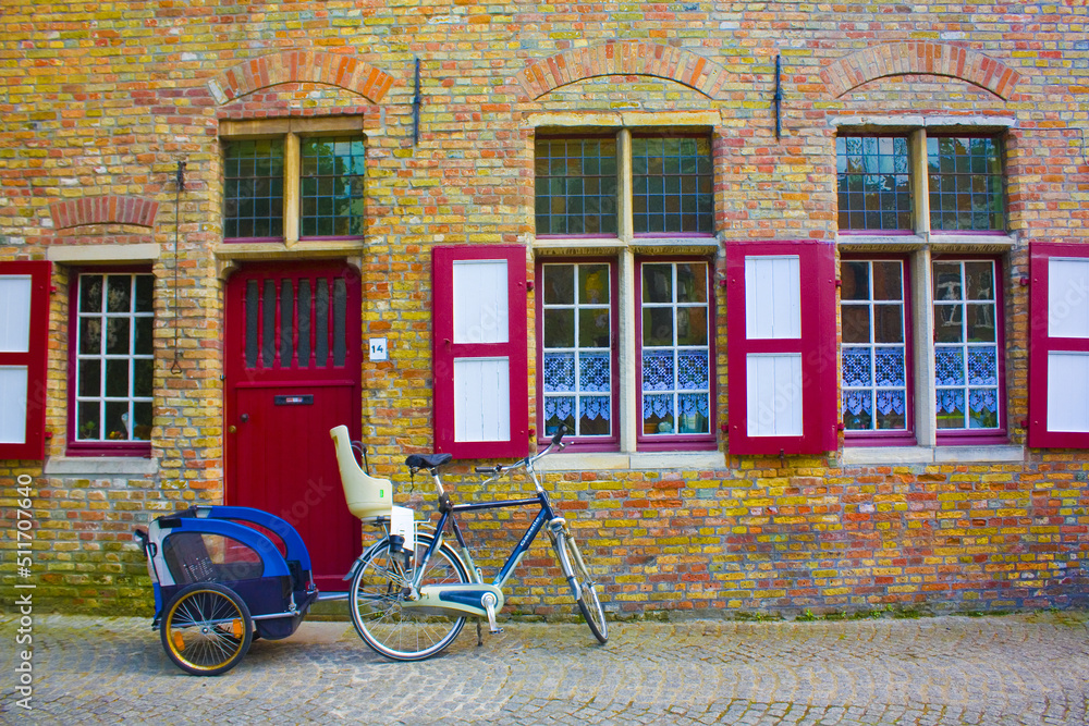 Bicycles on the pavement near a wall of old building in Brugge, Belgium