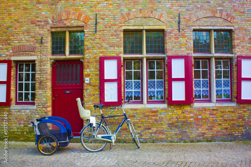 Bicycles on the pavement near a wall of old building in Brugge, Belgium