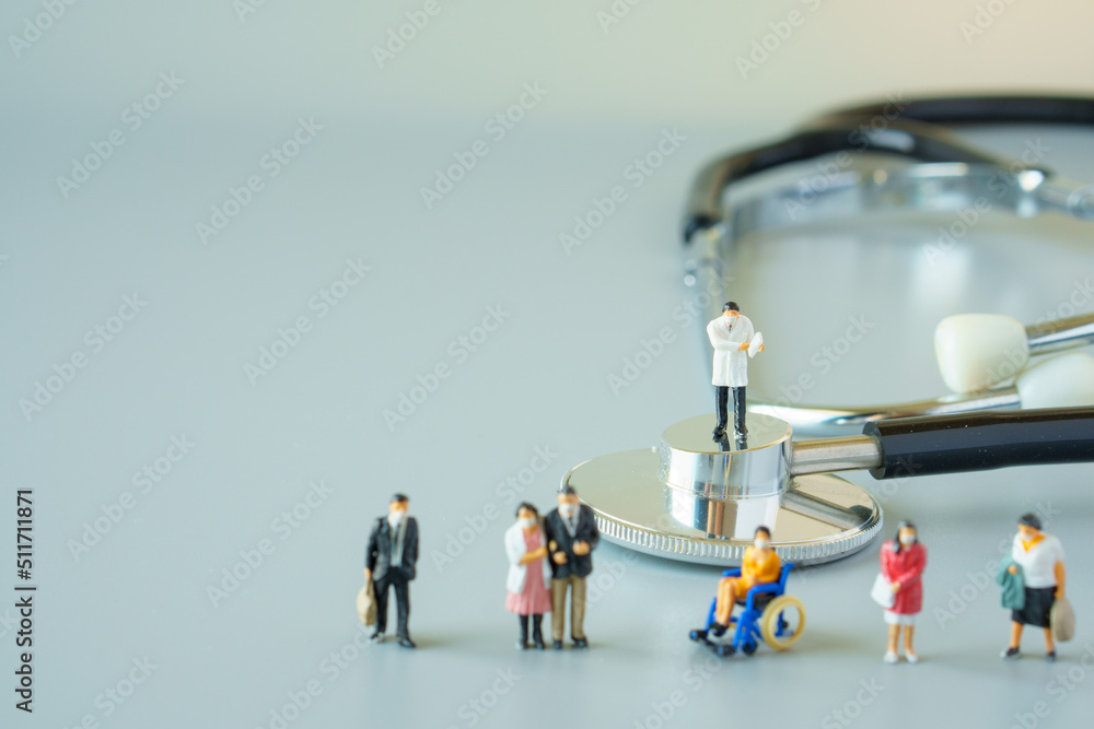 selective focus of miniature doctor on black stethoscope and miniature people with mask on white ground to solution for Annual Health Check up. selective focus of miniature doctor on black stethoscope and miniature people with mask on white ground to solution for Annual Health Check up.