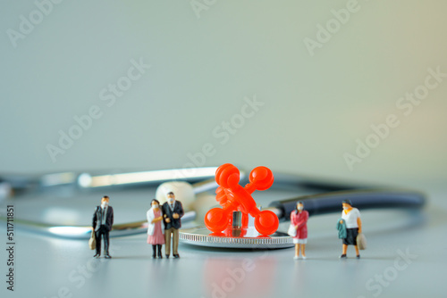 selective focus of red virus on black stethoscope and miniature people with mask on white ground to solution for Annual Health Check up.