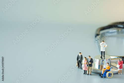selective focus of miniature doctor on black stethoscope and miniature people with mask on white ground to solution for Annual Health Check up.