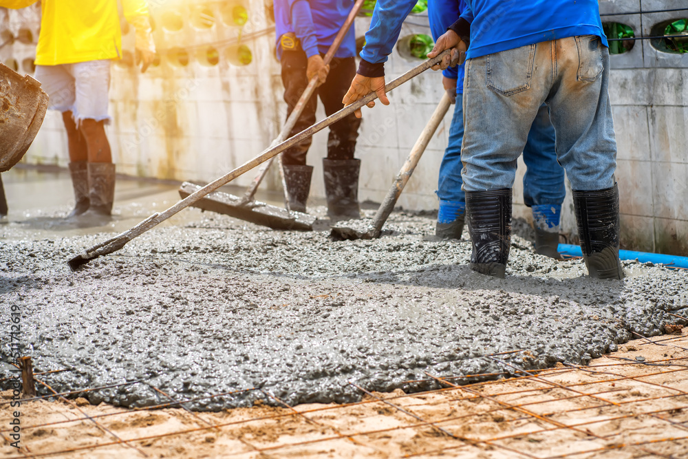 Construction workers are pouring concrete pavement at the construction site. Construction workers are pouring concrete pavement at the construction site.