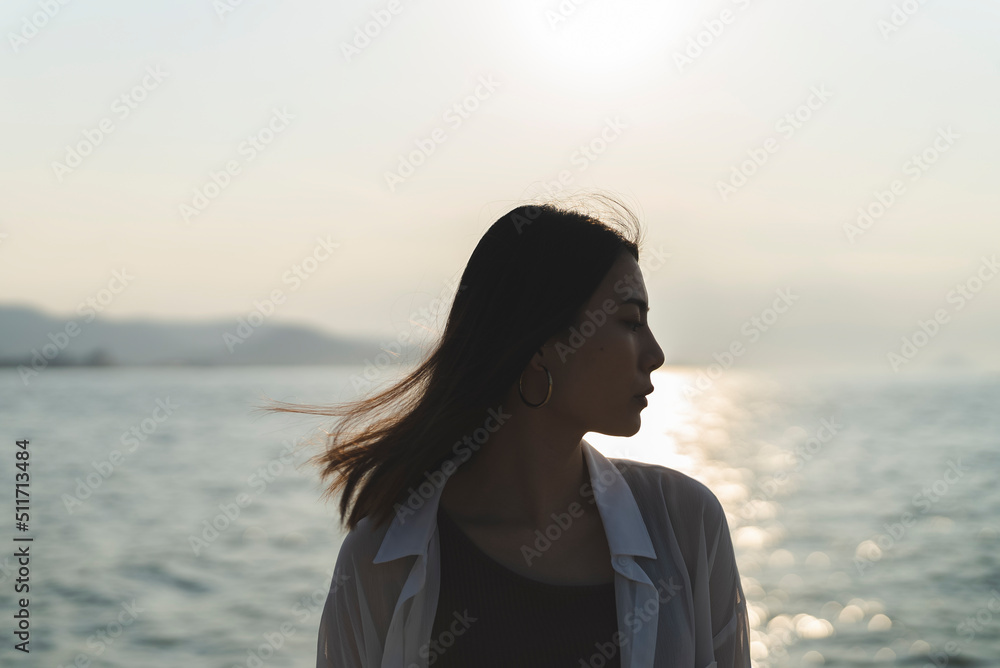 夕暮れの海にいる女性