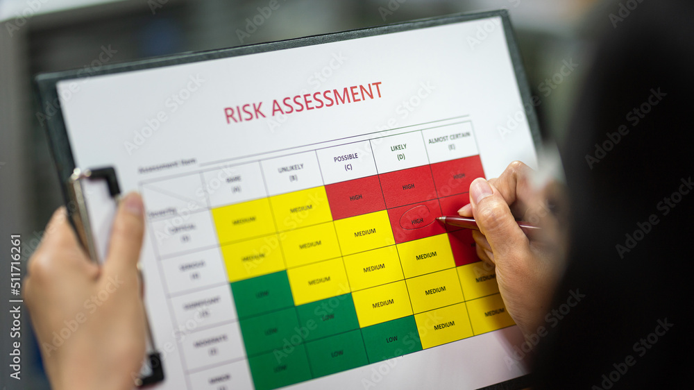 Action of a person is using ballpoint pen to marking on the risk assessment matrix table at "High risk" level. Industrial or business working action scene photo. Close-up and selective focus. - obrazy, fototapety, plakaty 