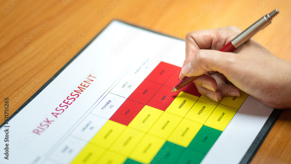 Action of a person is using ballpoint pen to marking on the risk assessment matrix table at Action of a person is using ballpoint pen to marking on the risk assessment matrix table at