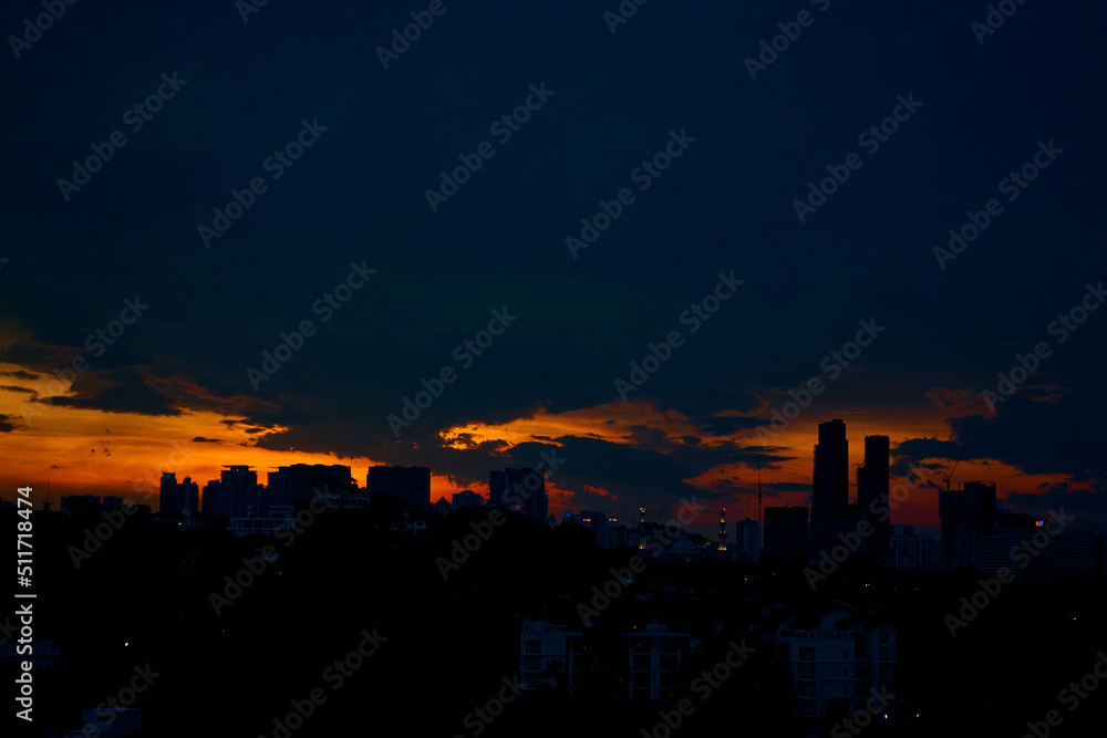 sunset with dark rainy clouds over modern city
