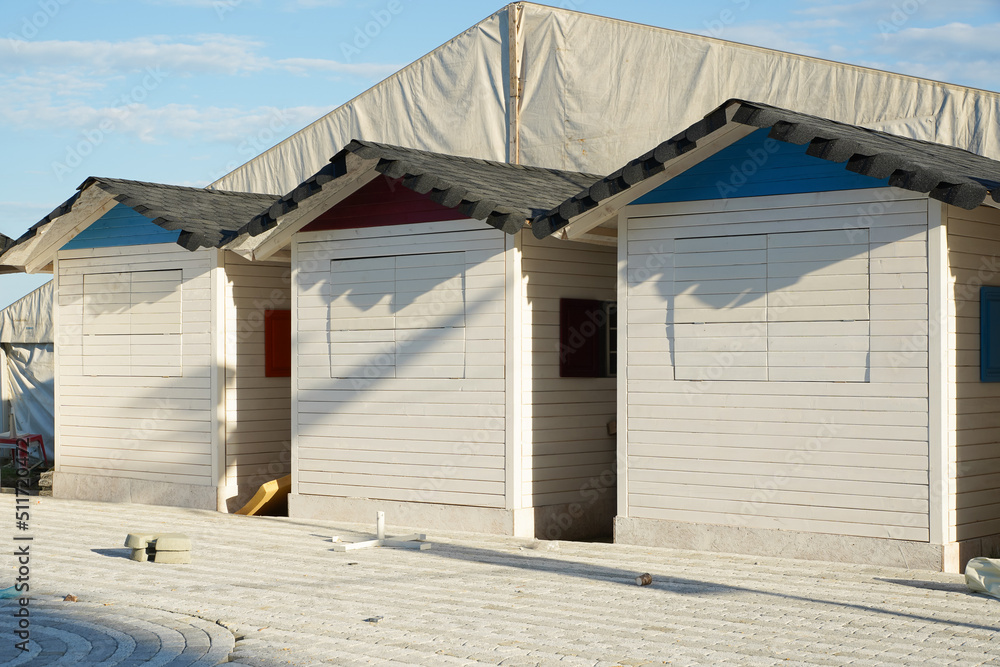 Naklejka premium white houses located on the beach waiting for traders to open them.