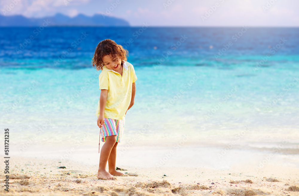 Little boy playing on tropical beach.