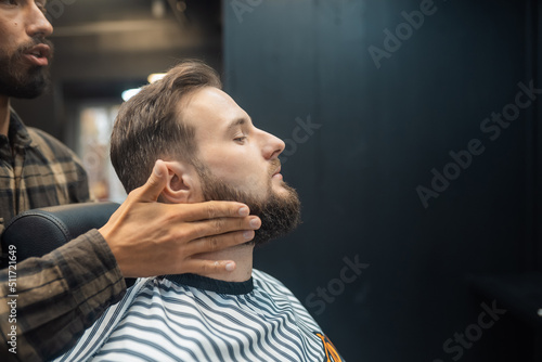 Facial applying lotion after shave in Barber shop.