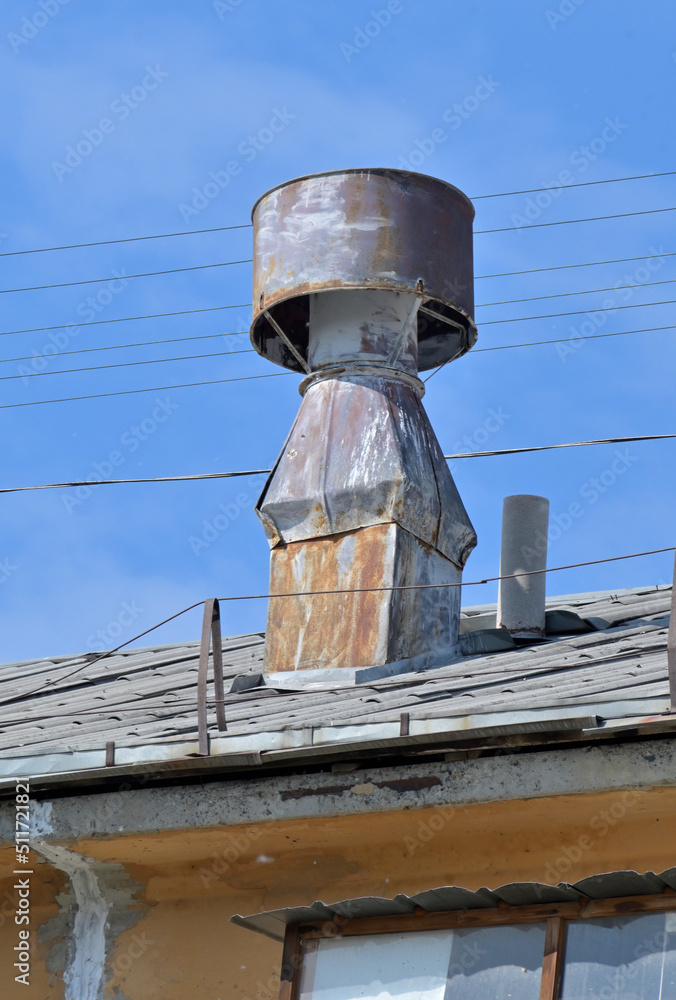 Exhaust ventilation on the roof of an old building on a summer day