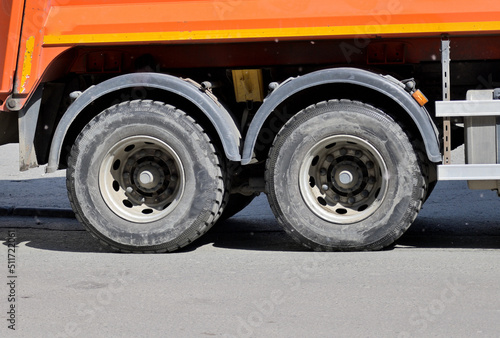 Rear wheels of a garbage truck close-up on a sunny day