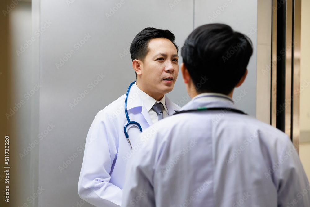 Asian male doctor in white uniform standing in passenger or cargo elevators at modern hospital. Healthcare medical and medicine concept. Asian male doctor in white uniform standing in passenger or cargo elevators at modern hospital. Healthcare medical and medicine concept.