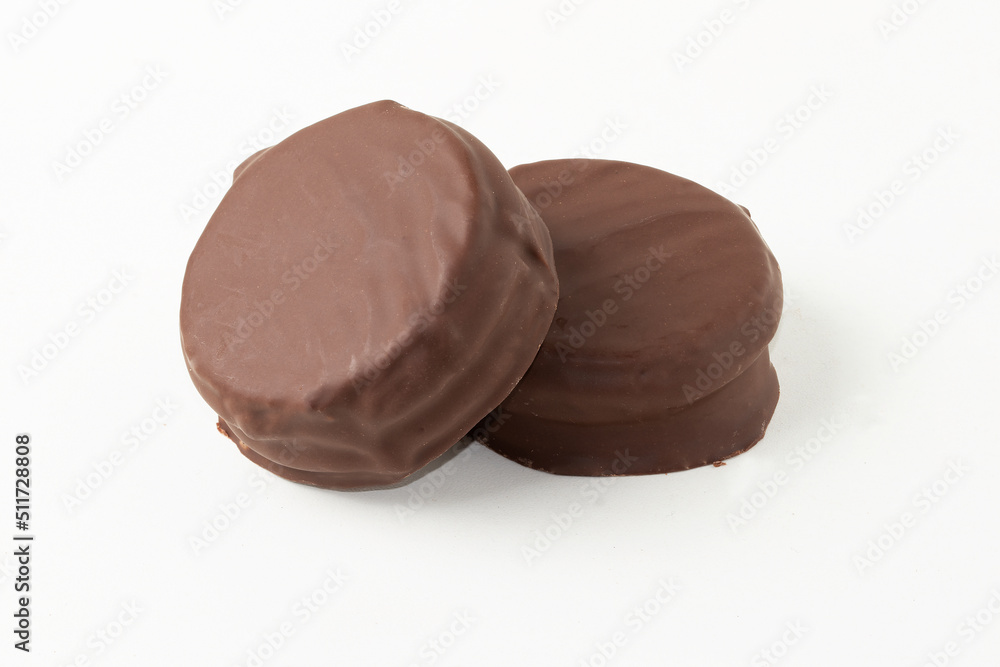 Two black chocolate alfajor isolated on white background. Two black chocolate alfajor isolated on white background.