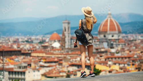 Young attractive smiling girl tourist in hat exploring new Europe city at summer holiday at Florence