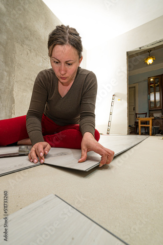 Installing a quartz vinyl floor, a woman performs installation work.