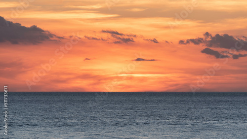 Beautiful colorful dramatic deep vibrant sunset over ocean landscape image