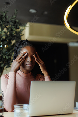 Young unhappy afro american woman with dreadlocks crying covering eyes with hands in coffee house closeup. Depressed black girl suffering, despaired, upset. Tiredness, unfair, troubles.