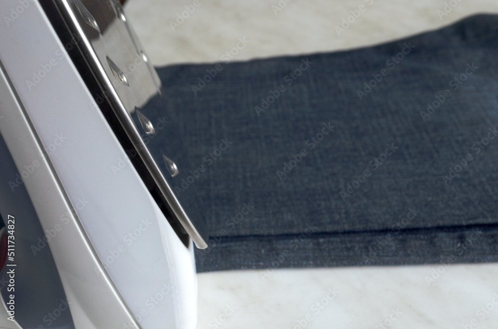 steam iron with metal sole on the background of jeans for ironing steam iron with metal sole on the background of jeans for ironing