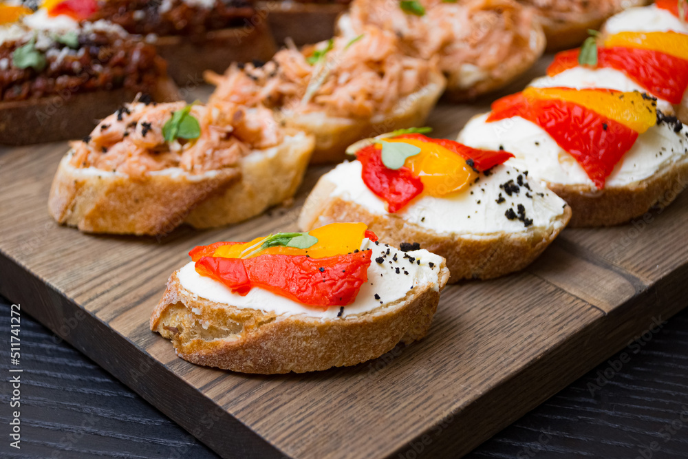 Bruschetta with different kinds of spreads. A set of appetizers on a wooden board. Catering serving.