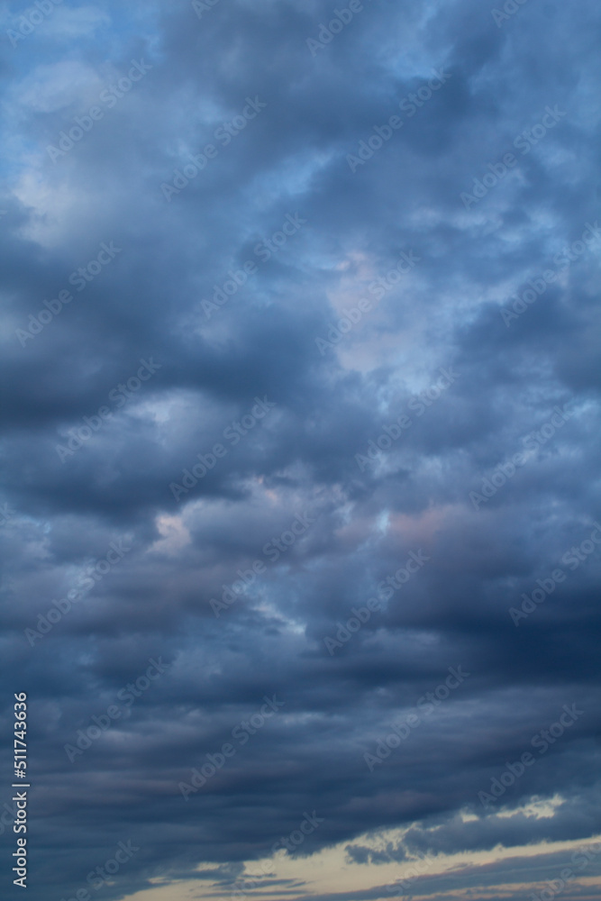 Natural background. Blue sky with clouds at sunset. Location vertical.