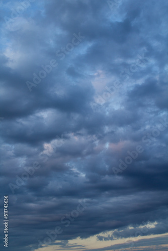 Natural background. Blue sky with clouds at sunset. Location vertical.