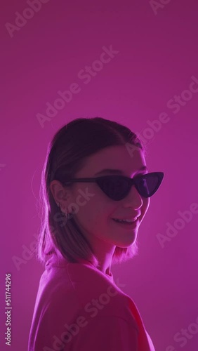 Wallpaper Mural Sunglasses fashion. Cool woman. Trendy accessory. Confident stylish pretty girl winking eye in vibrant neon light isolated on pink background vertical. Torontodigital.ca