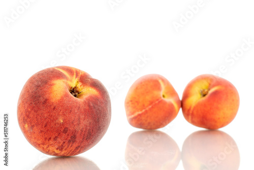 Three sweet organic peaches, close-up, isolated on white background.