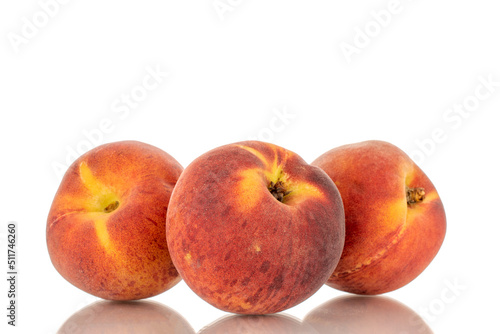 Three sweet organic peaches, close-up, isolated on white background.