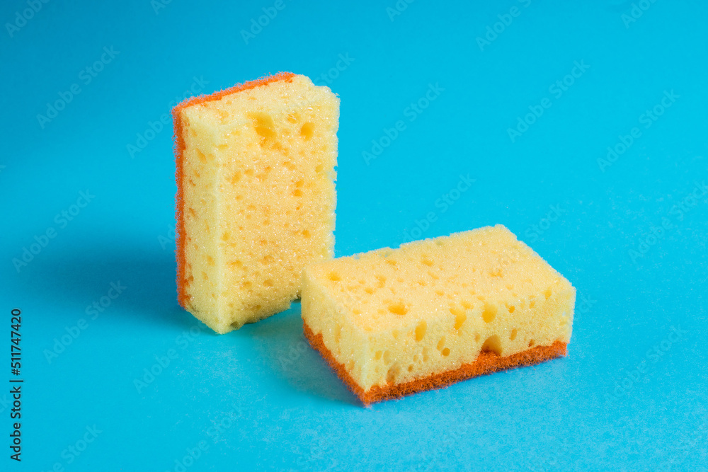 Yellow porous sponges for cleaning on a blue background with copy space. Home cleaning concept Yellow porous sponges for cleaning on a blue background with copy space. Home cleaning concept