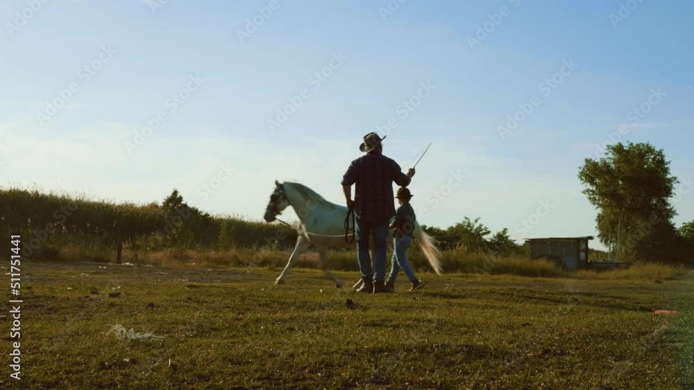 Local farmer and his son training his horse at his ranch. Slow motion Local farmer and his son training his horse at his ranch. Slow motion