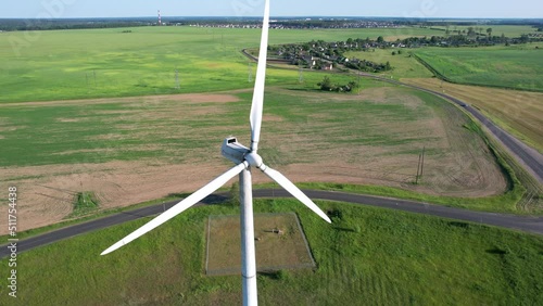 NEG Micon windmill. Aerial view of windmill in rural landscape. Aerial drone shot of fast spinning wind turbine photo