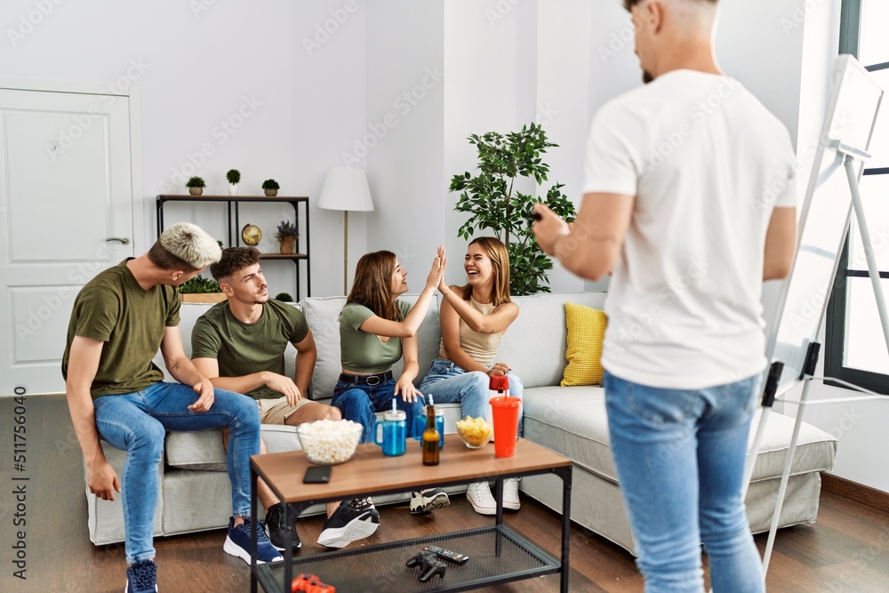 Group of young friends smiling happy playing game at home. Group of young friends smiling happy playing game at home.