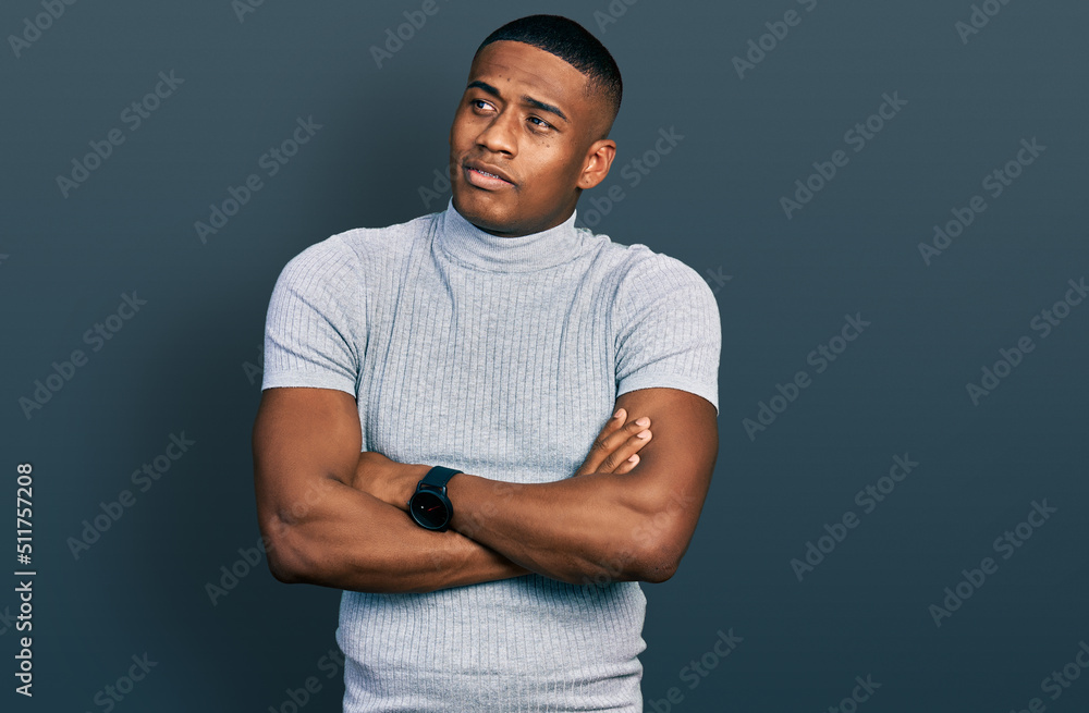 Young black man wearing casual t shirt looking to the side with arms crossed convinced and confident Young black man wearing casual t shirt looking to the side with arms crossed convinced and confident