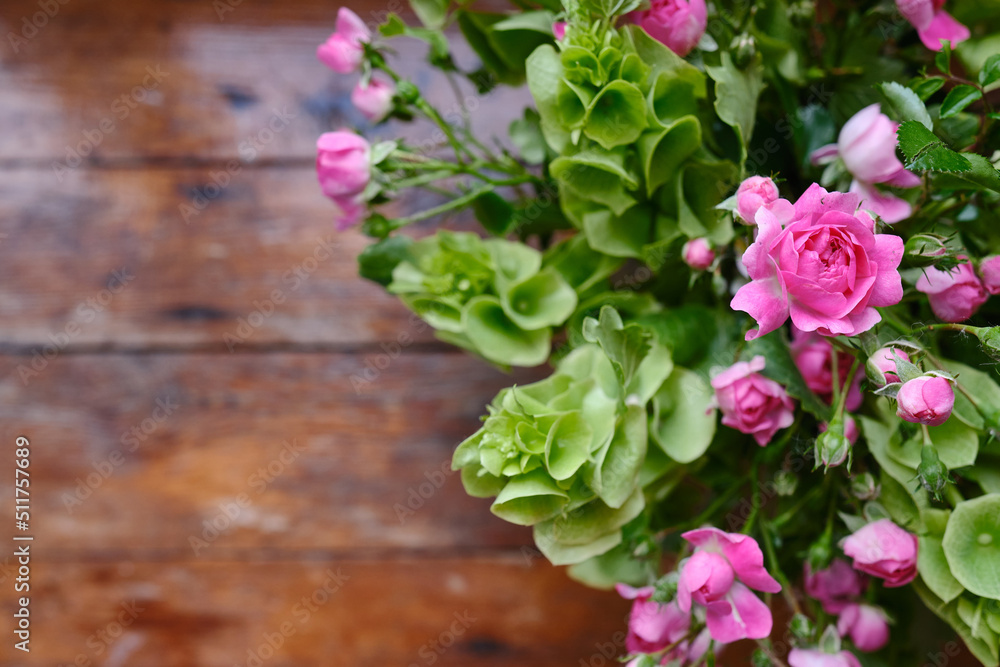 Bouquet of pink-green flowers on a wooden background. Roses top view. Place for text. Holiday postcard. Copy space Bouquet of pink-green flowers on a wooden background. Roses top view. Place for text. Holiday postcard. Copy space