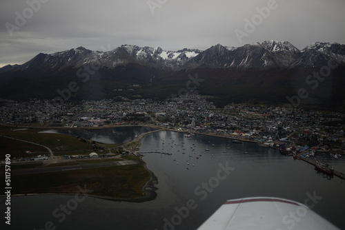 the photo captures the moment of takeoff and flight by plane over Ushuaia     a city and port in southern Argentina.