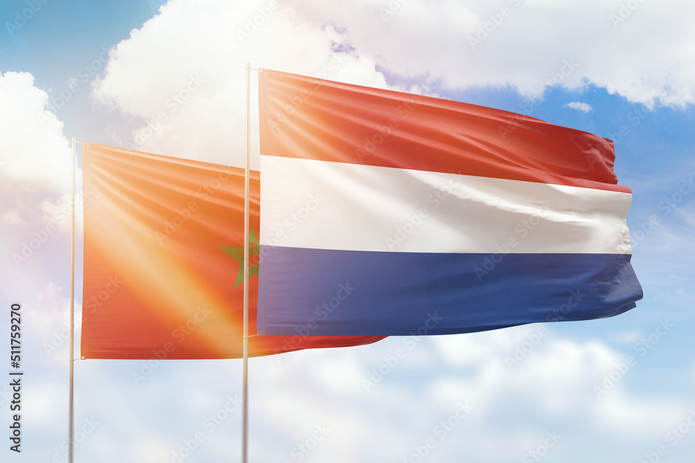 Sunny blue sky and flags of netherlands and morocco Sunny blue sky and flags of netherlands and morocco