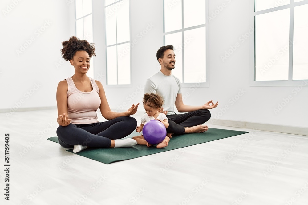 Couple and daughter smiling confident training yoga at sport center Couple and daughter smiling confident training yoga at sport center