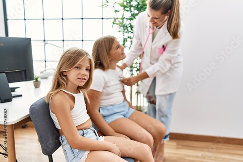 Tableau sur toile Mother and daughters doctor and patient auscultating heart having medical sessio