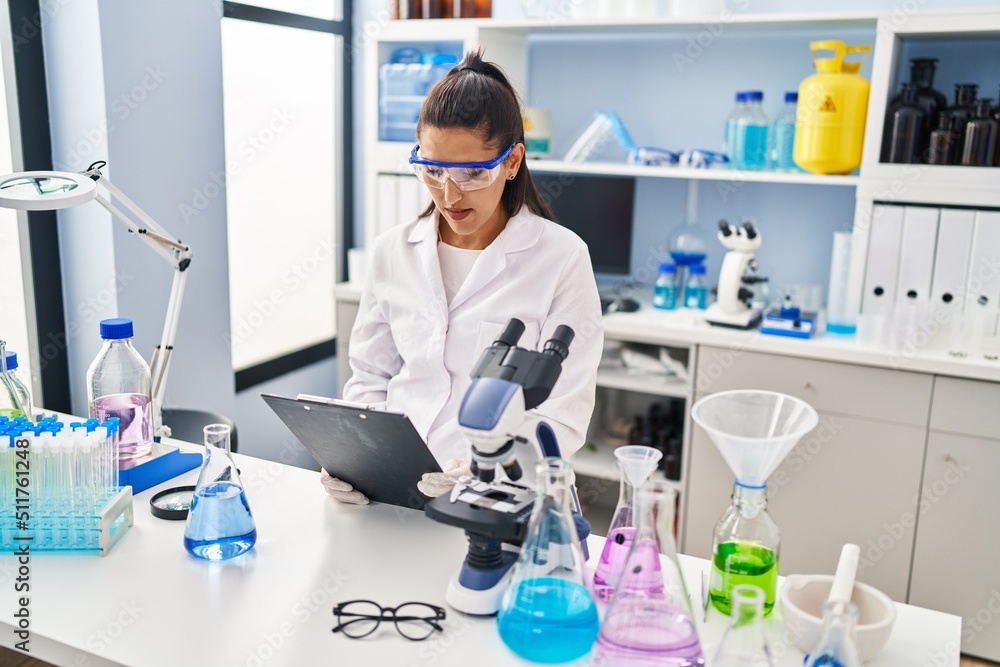 Young hispanic woman wearing scientist uniform working at laboratory Young hispanic woman wearing scientist uniform working at laboratory